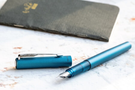 Parker Vector XL Fountain Pen Teal on a marble table with notebook