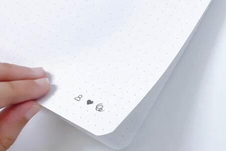 Endless Creative Block Notepad with hand turning the page at bottom right near the organisation icons