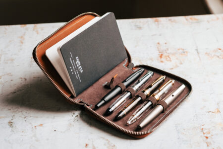 Endless Companion Leather Pen Pouch fully open with assorted pens and notebook